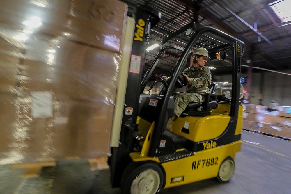 US Army Staff Sgt Amber Knickman a Supply Specialist with the New Jersey Army National Guard moves pallets of gear during a Rapid Fielding Initiative RFI